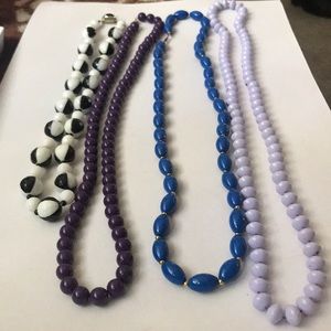 4 long costume jewelry necklaces.